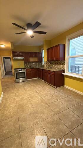 A kitchen with a fan and tiled floor.