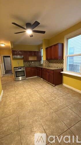 A kitchen with a fan and tiled floor.