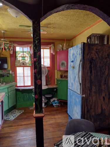 A kitchen with green cabinets and a wooden floor.