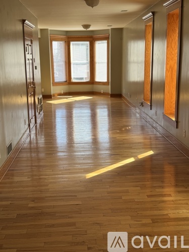 A long hallway with wood floors and a logo that says "avaiL" on the bottom right.