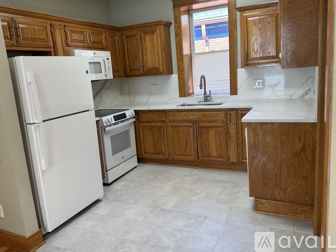 A kitchen with wooden cabinets and a white fridge.