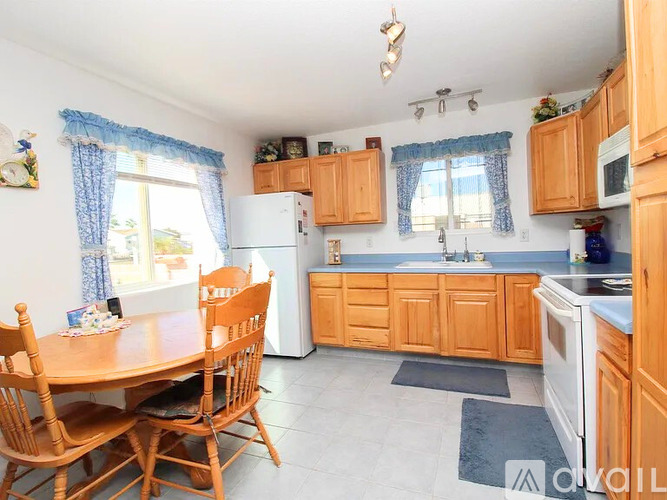 A kitchen with wooden cabinets and a white refrigerator.