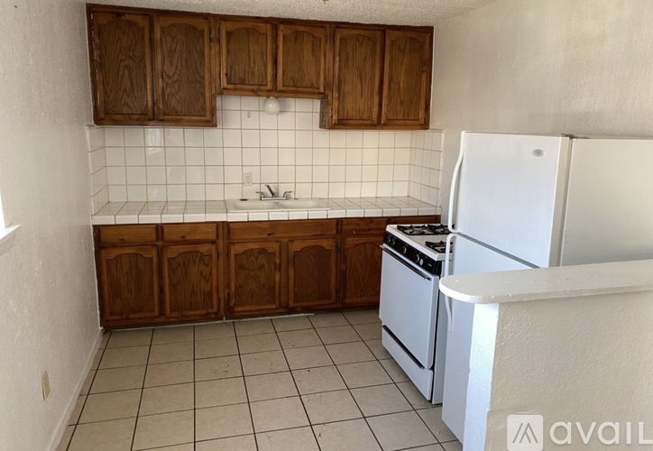 A kitchen with white appliances and wooden cabinets.