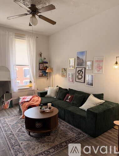 A living room with a green couch, a coffee table, and pictures on the wall.