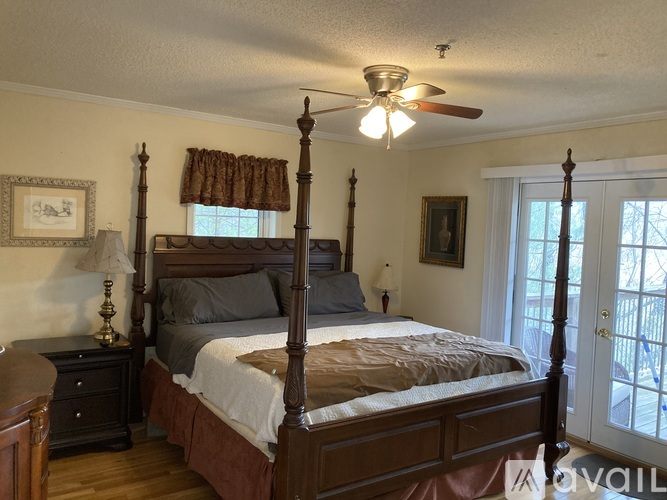 A bedroom with a four poster bed and a ceiling fan.