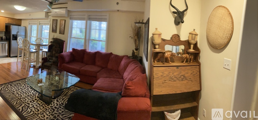 A living room with a red couch and a glass coffee table.