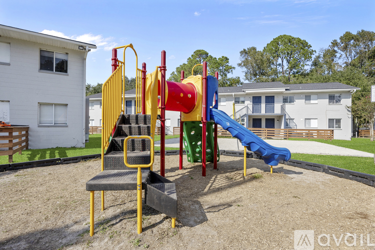 A playground with a yellow and red slide and a blue slide.