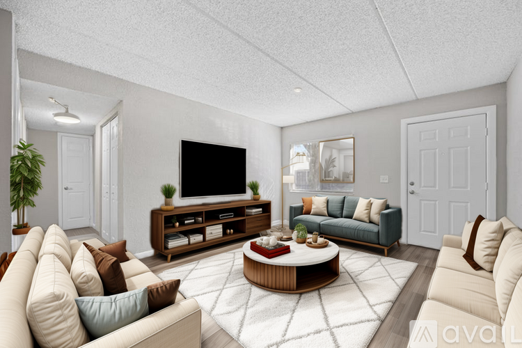 A living room with a large television and a coffee table in the center.