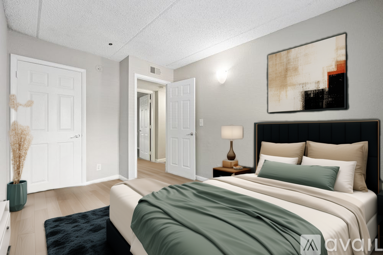 A bedroom with a large bed and a painting on the wall.