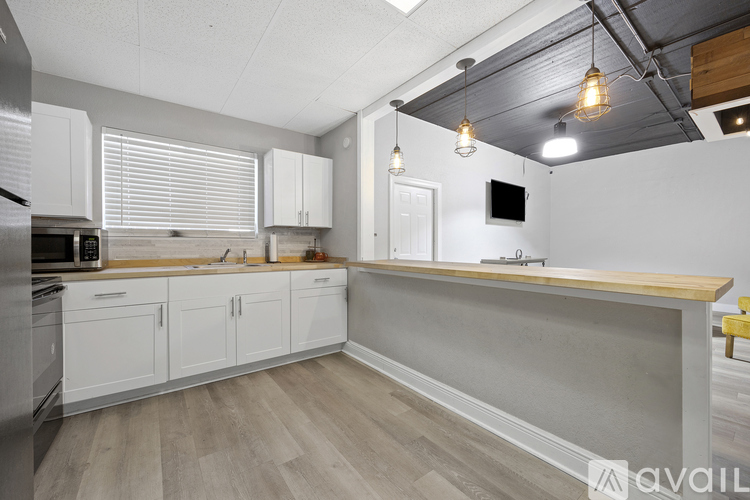 A kitchen with white cabinets and a wooden countertop.