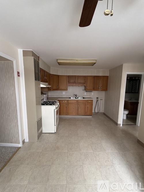 A kitchen with a white fridge and wooden cabinets.