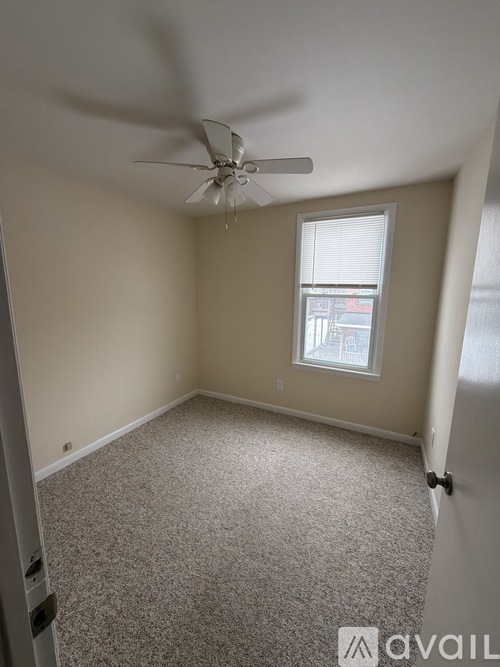 A room with a ceiling fan and a window.