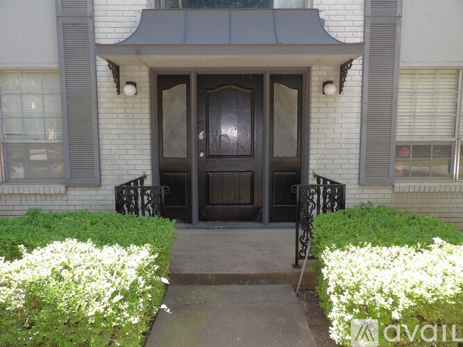 A house entrance with a black door and a small porch.
