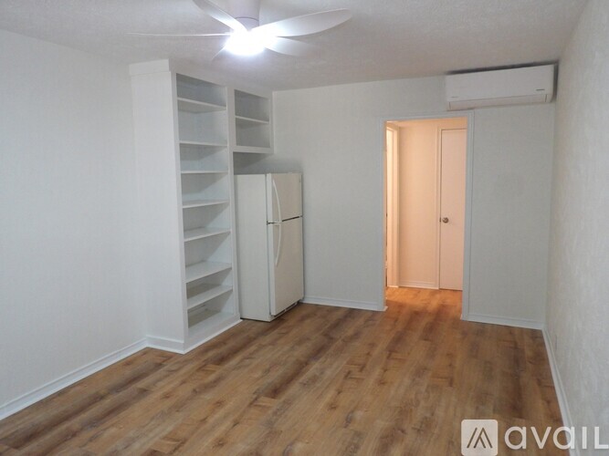 A room with a wooden floor and a ceiling fan.