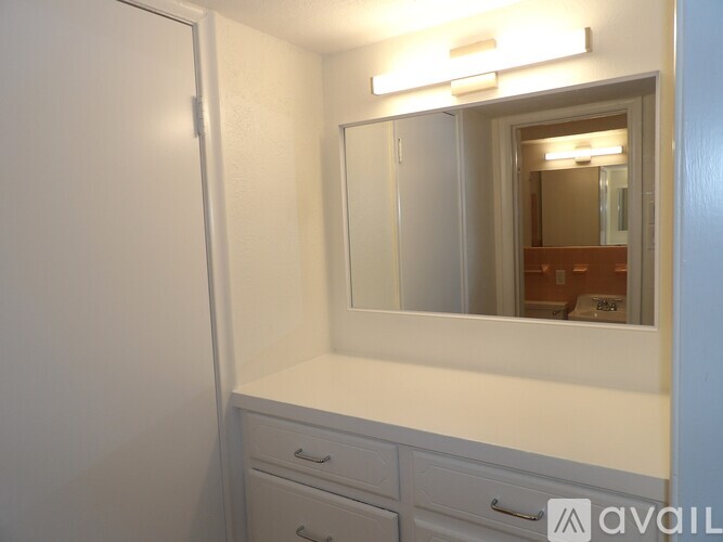A white bathroom vanity with a mirror and a light above it.