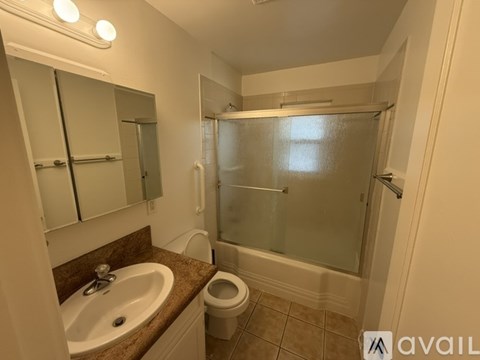 A bathroom with a sink, toilet, and shower.