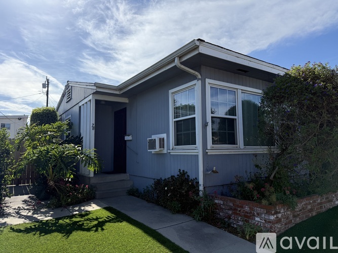 A house with a grey exterior and a white window is for sale.