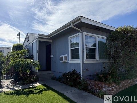 A house with a grey exterior and a white window is for sale.
