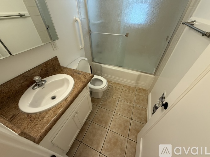 A bathroom with a sink, toilet, and shower.