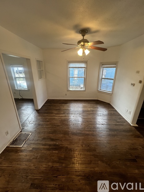 A room with wooden floors and a ceiling fan.