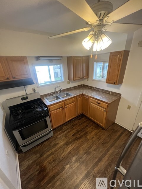 A kitchen with wooden cabinets and a black stove top oven.