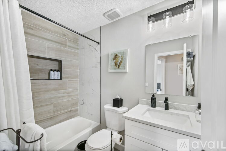 A bathroom with a toilet, sink, and mirror.