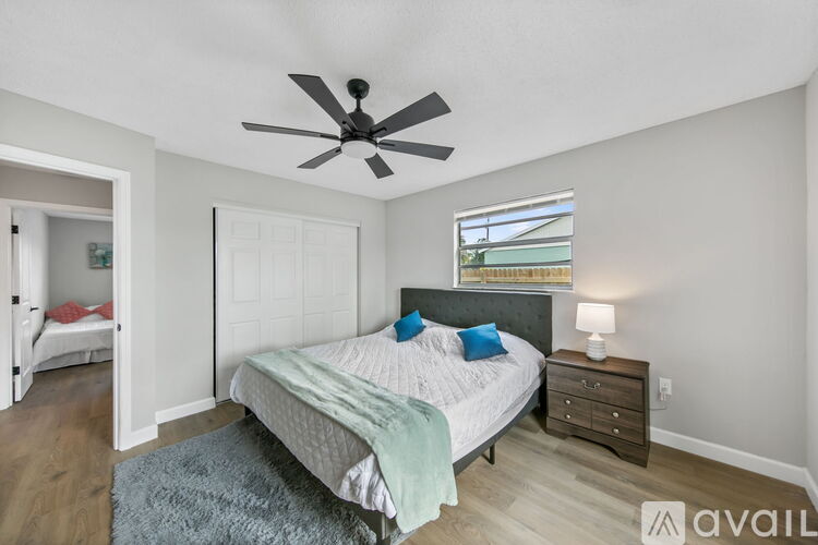 A bedroom with a bed, dresser, and window.