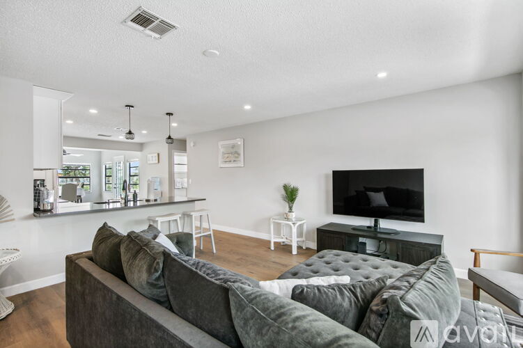 A living room with a grey couch and a black television.