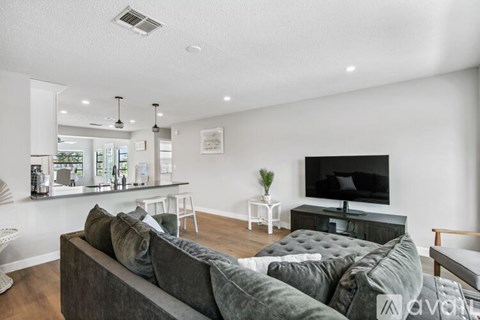 A living room with a grey couch and a black television.