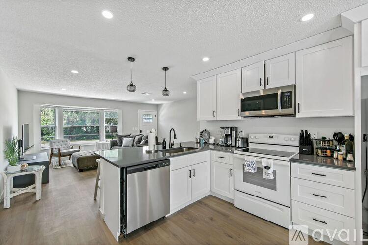 A modern kitchen with white cabinets and stainless steel appliances.
