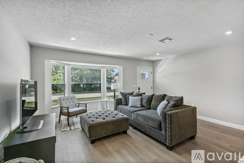 A living room with a grey couch and a television.