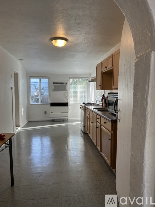 A kitchen with wooden cabinets and a tiled floor.