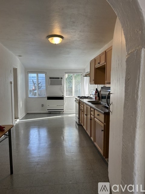 A kitchen with wooden cabinets and a tiled floor.