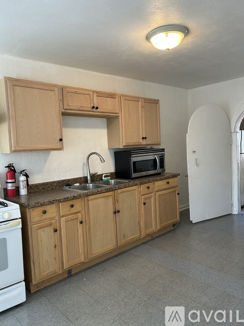 A kitchen with wooden cabinets and a white oven.