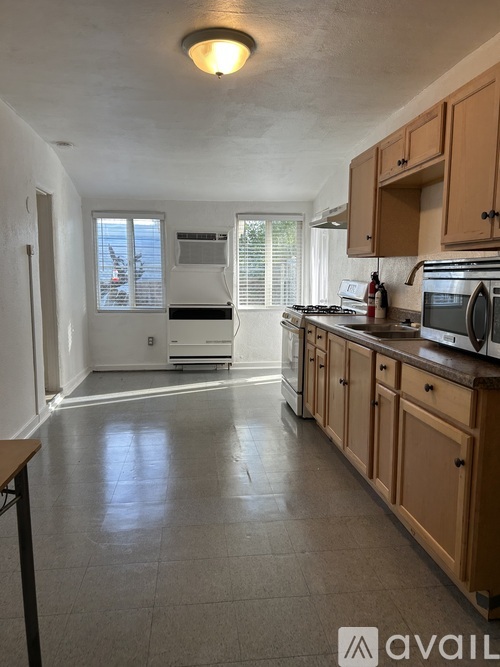 A kitchen with wooden cabinets and a tiled floor.