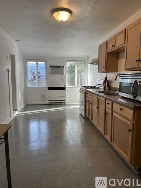 A kitchen with wooden cabinets and a tiled floor.