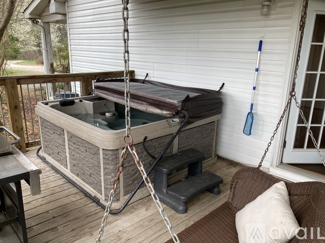 A hot tub is hanging from a chain on a porch.