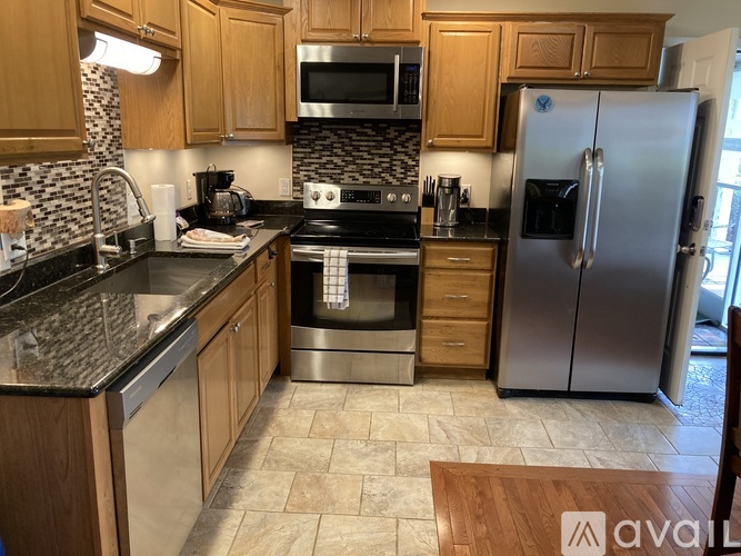 A kitchen with wooden cabinets and a tile backsplash.