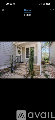 A house with a front porch and a black railing.