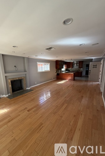 A living room with wooden floors and a fireplace.