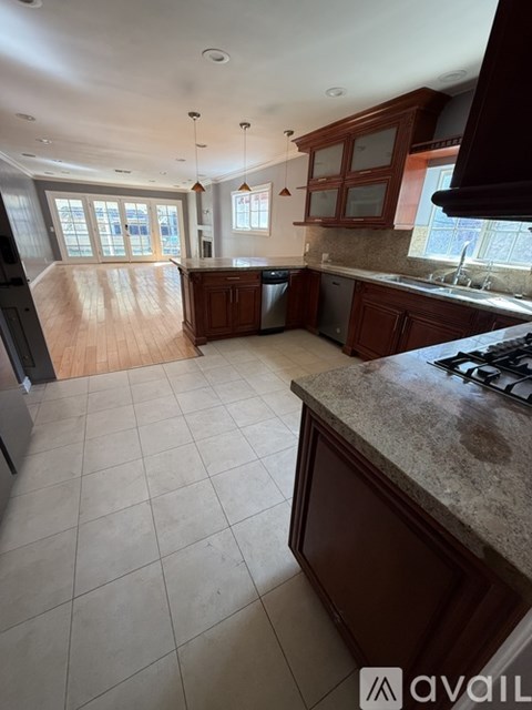 A kitchen with brown cabinets and a granite countertop.