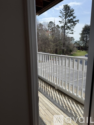 A view from a window looking out to a deck and trees.
