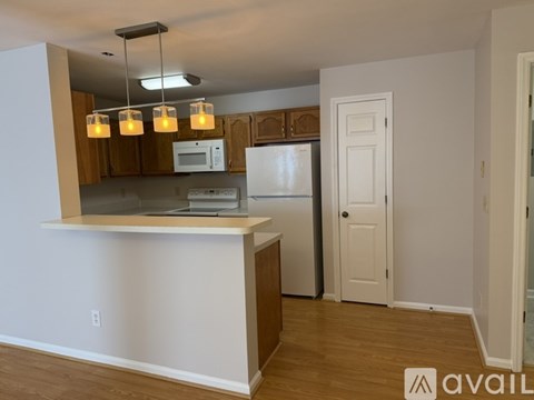A kitchen with a white refrigerator and wooden cabinets.