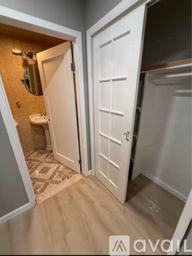 A bathroom with a sink, mirror, and toiletries.