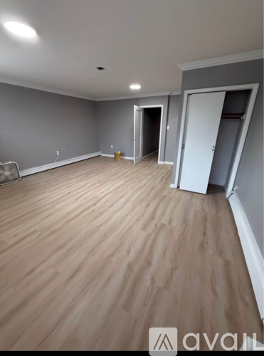 A room with wooden flooring and a white door.
