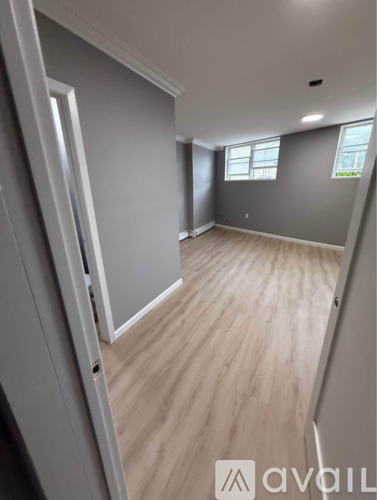 A room with wooden flooring and a window.