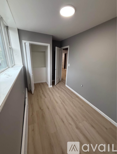 A room with a window on the left and a door on the right.