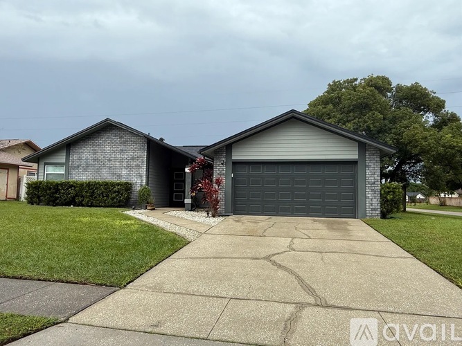 A house with a grey garage door and a driveway leading to it.