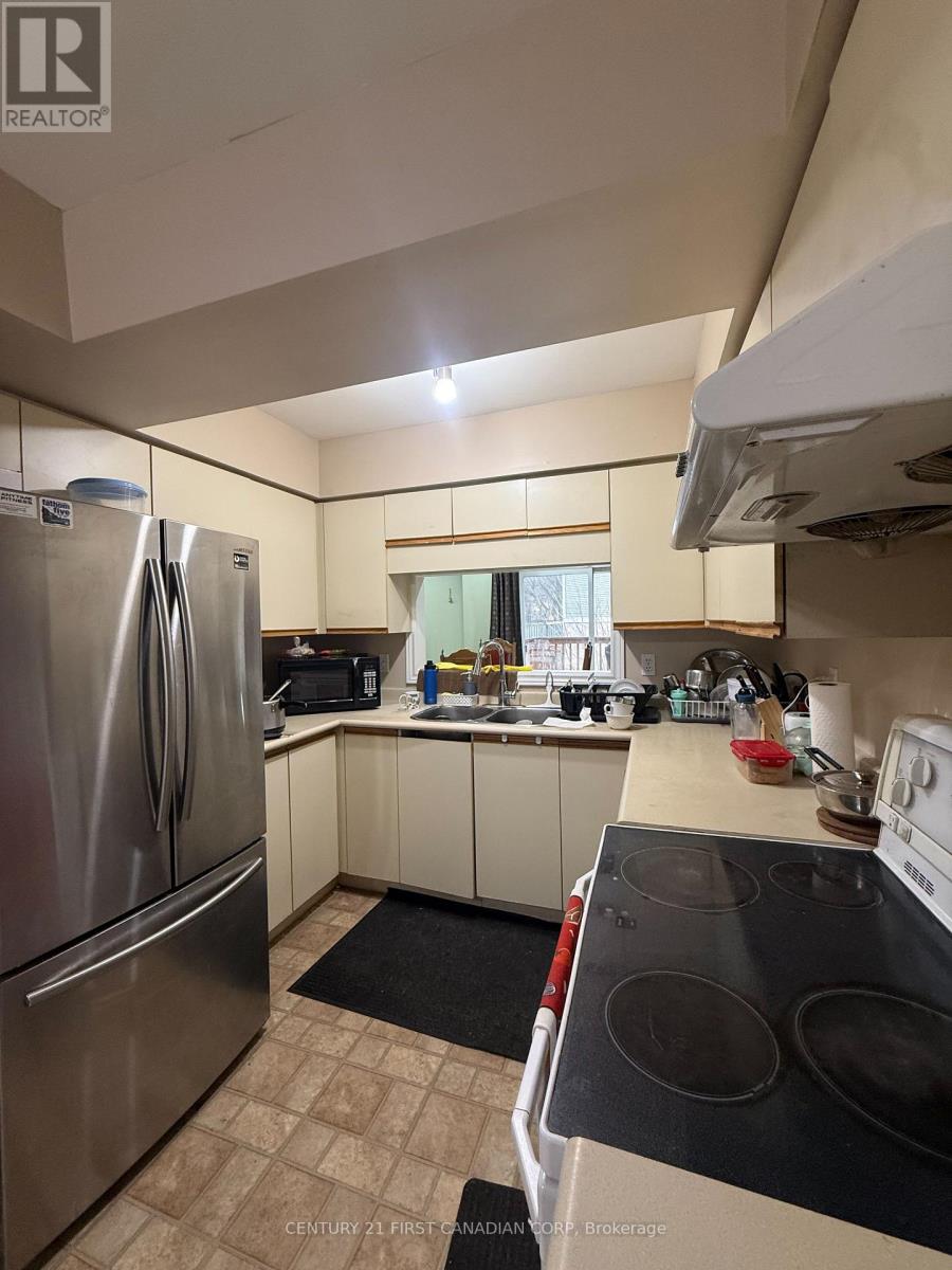 A kitchen with a stove top oven and a refrigerator.