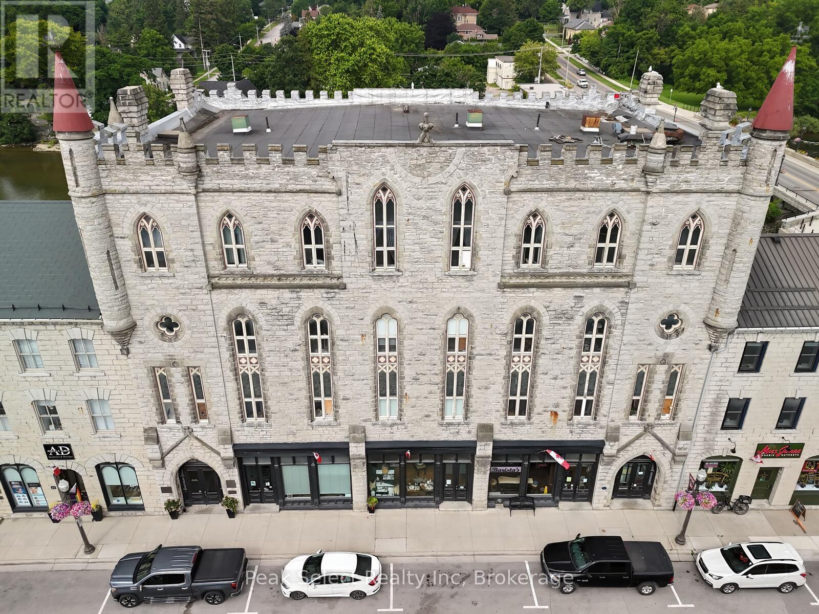 A castle-like building with a parking lot in front.